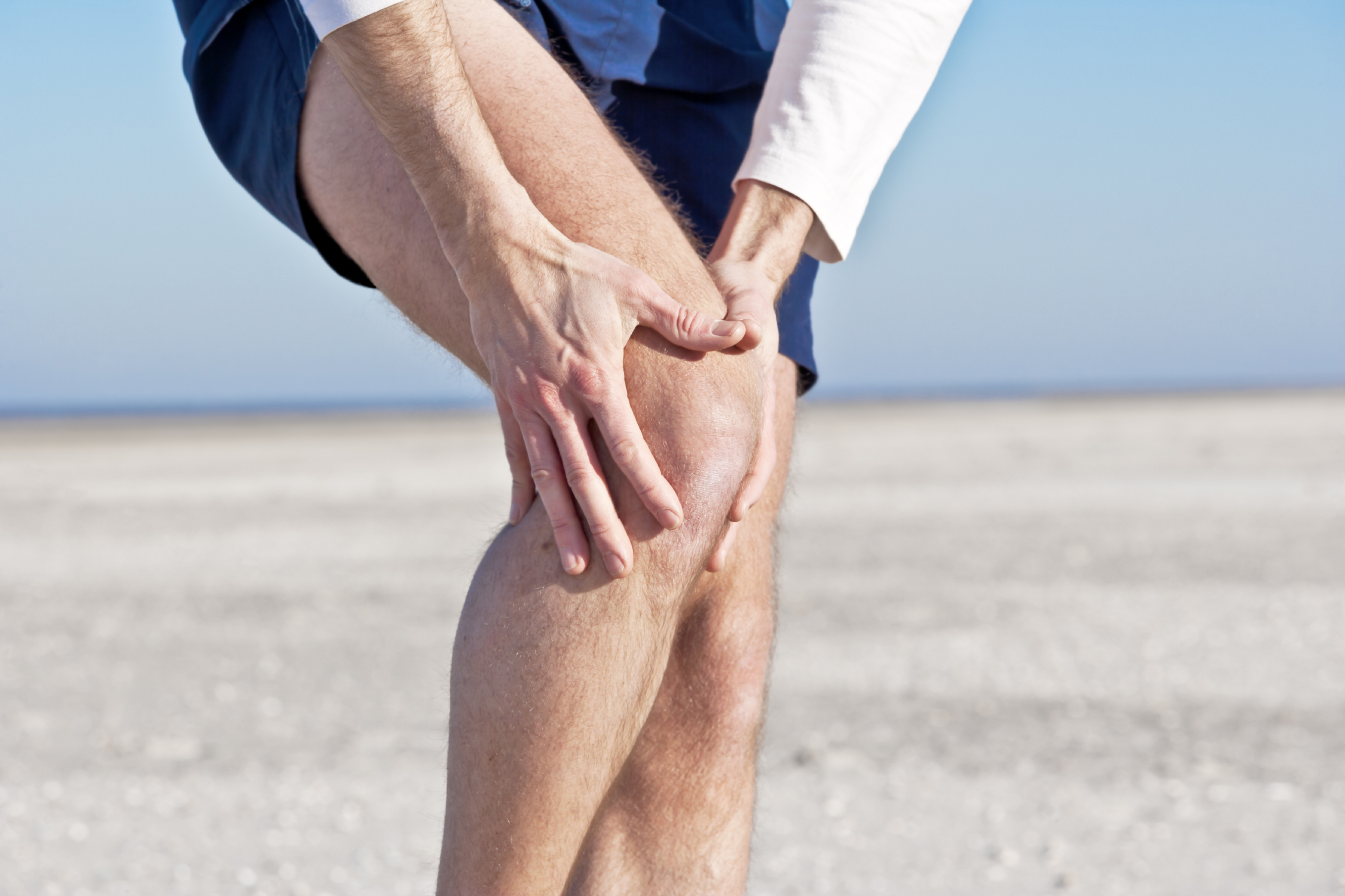 Болезнь суставов у мужчин. Боль в суставах. Боль в колене. Человек держится за колено.